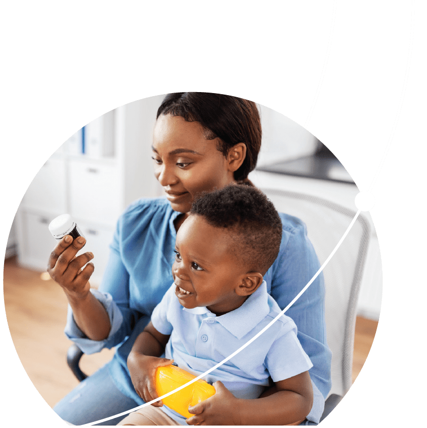 Woman with son on her lap looking at a pill bottle