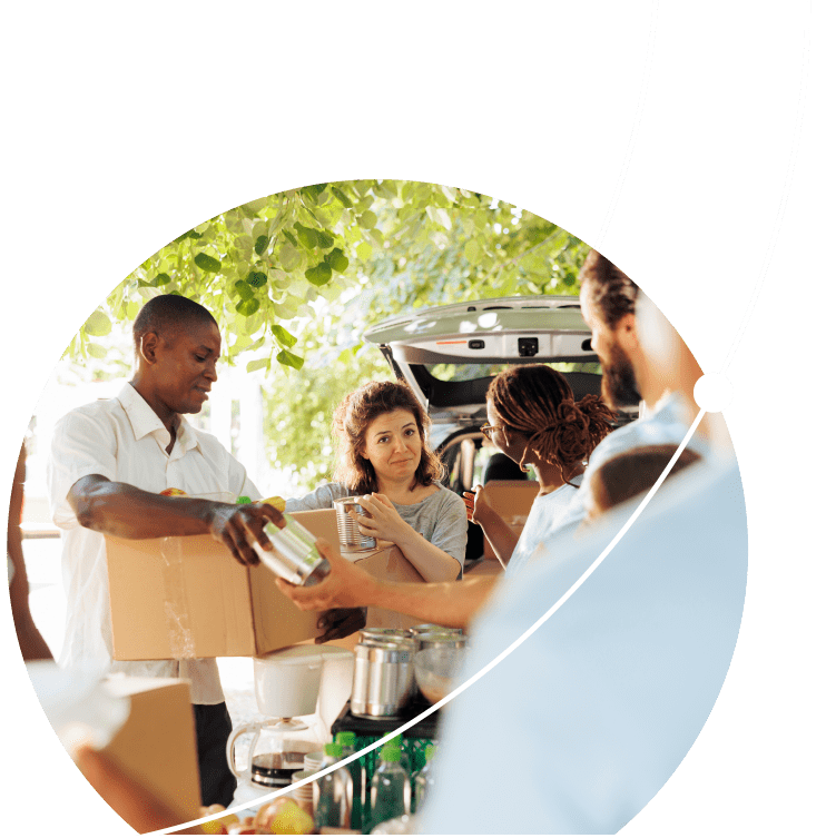 African american and caucasian charity workers helping the needy and distributing packages at a non-profit organization. Volunteers provide free food to the needy and offer shelter to homeless people.