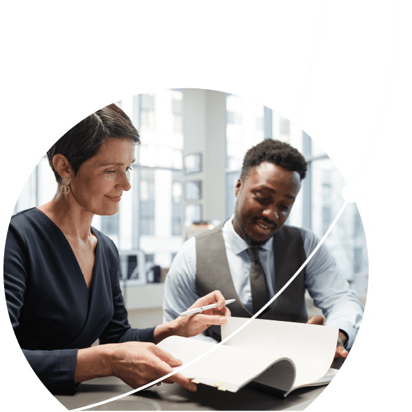 Elegant mature businesswoman signing documents with colleague in office