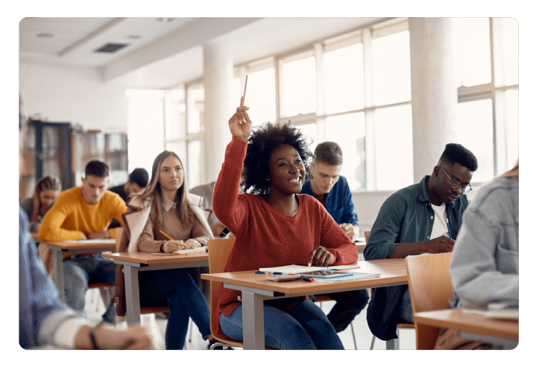 Happy black student raising arm to answer question while attending class with her university colleagues.