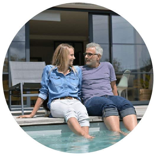 A couple sitting by their pool