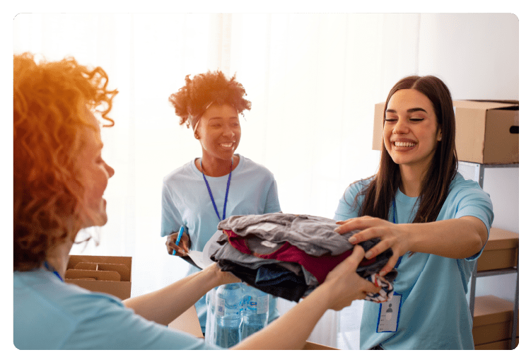 Volunteers pack canned goods into boxes during food drive. Helpful team of social workers. Group of mixed race people working in charitable foundation