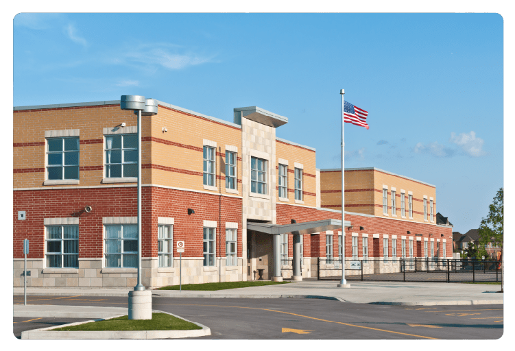 A new elementary school building with flagpole and parking lot.