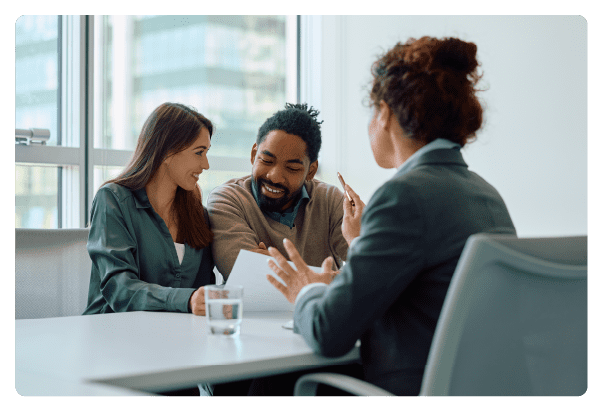 Happy couple analyzing contract while having a meeting with their financial advisor in the office. 